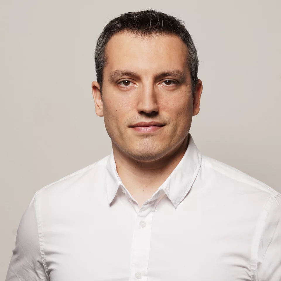 Porträt von Cristian Cristea in einem weißen Hemd vor einem neutralen Hintergrund